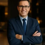 Director financiero de traje azul en lobby corporativo, proyectando liderazgo y confianza