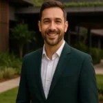 Gerente de sostenibilidad posando con traje verde frente a hotel con diseño ecológico